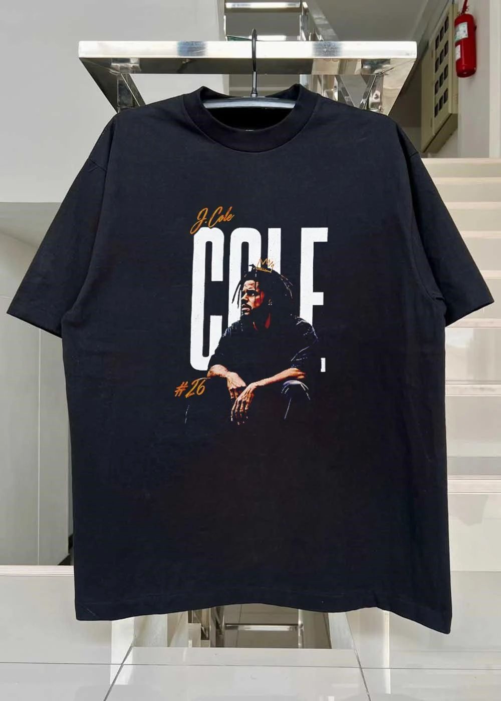 J Cole 26 Seated Rapper Wearing Small Gold Crown Distressed Background shirt